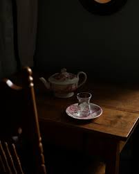 A perfectly balanced still life photo of vintage tea cups on a dark wooden table.